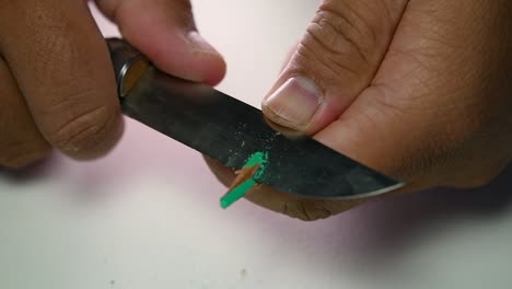 Footage-of-hands-slowly-sharpening-a-pencil-and-some-coloured-pencils-with-a-sharp-knife