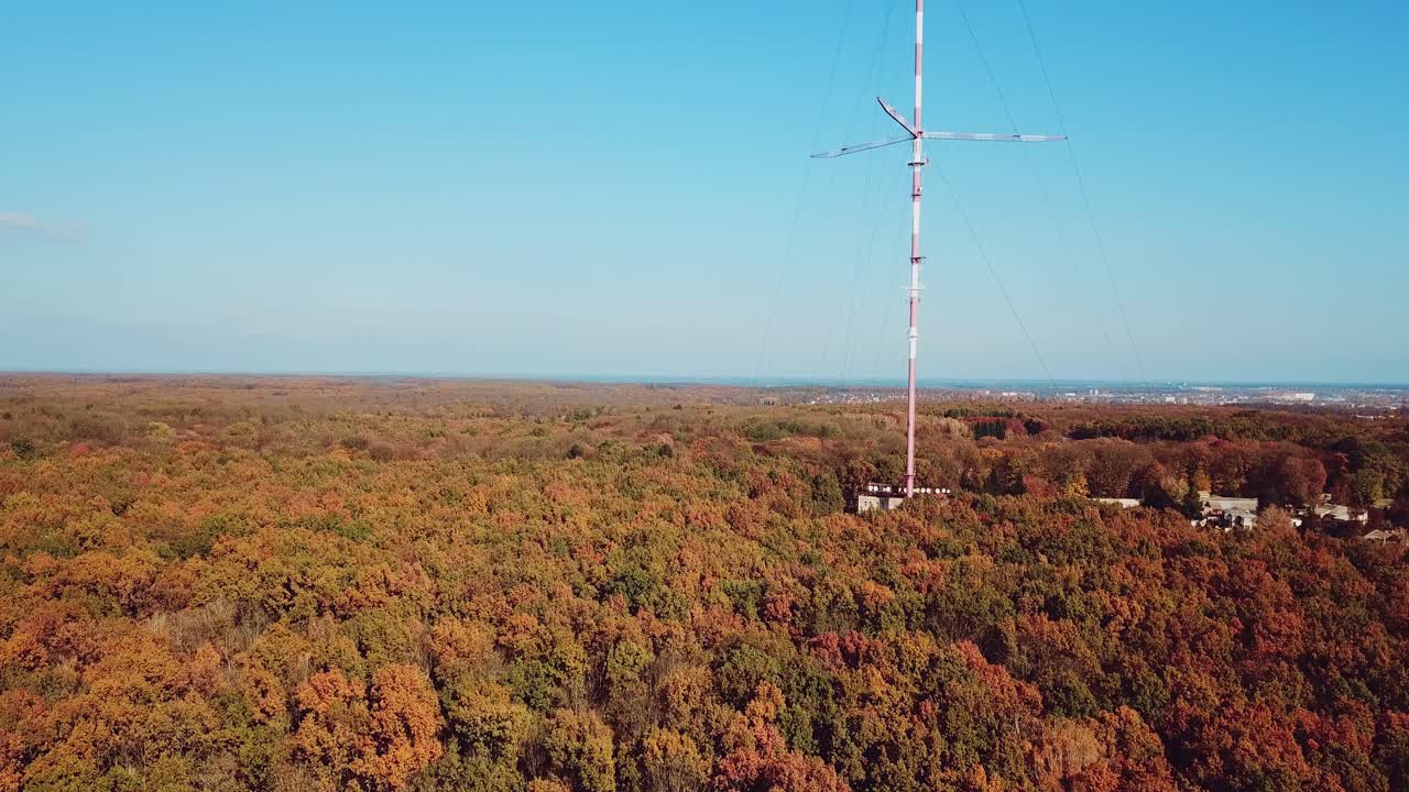 aerial view of the TV tower on the background of the forest. Camera motion up