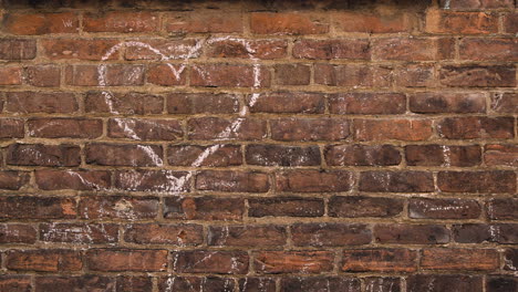 heart drawn in chalk on brick wall - handheld