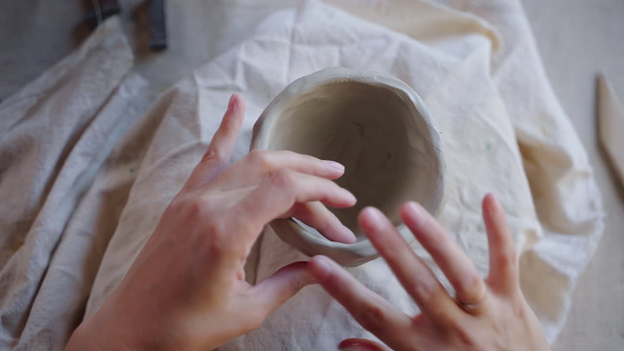 manos formando un cuenco de arcilla