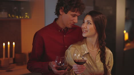 romantic couple enjoying a glass of wine at home