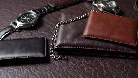 men's leather wallets and watches on a textured surface