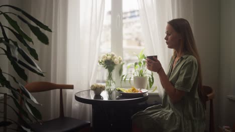 woman enjoying a meal by the window