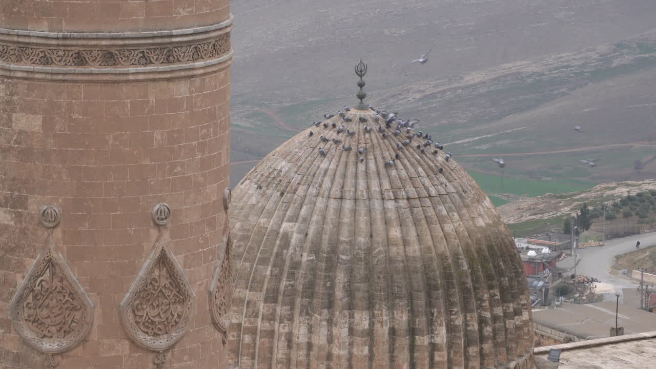 a medida que la cámara se aleja, vemos el minarete y la cúpula de la gran mezquita mardin