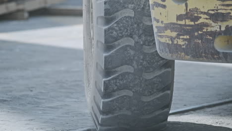 close-up of a truck wheel in motion at a shipping port, daylight, industry in action