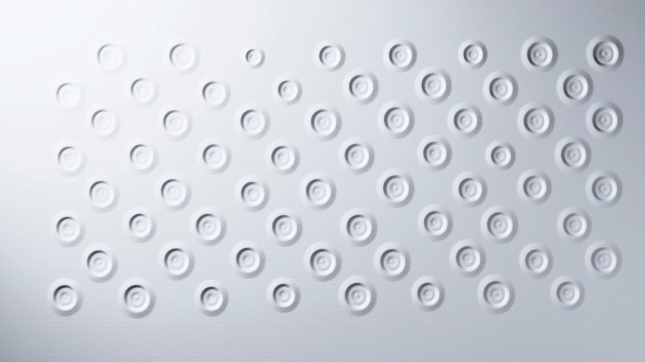Shallow circular depressions gradually appear across pale matte panel, shifting from sparse impressions into denser organized repetition and smooth relief under soft diffuse upper-left light