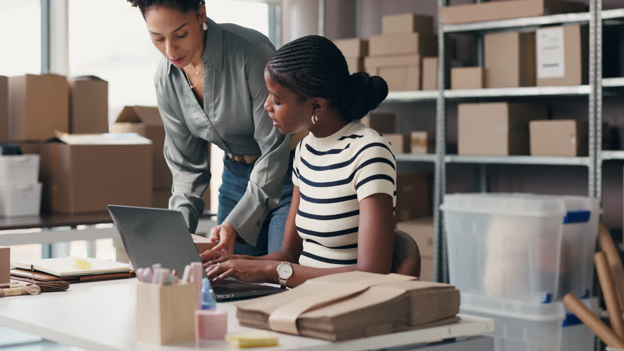 Two Women Collaborating on Laptop for Online Business Shipping