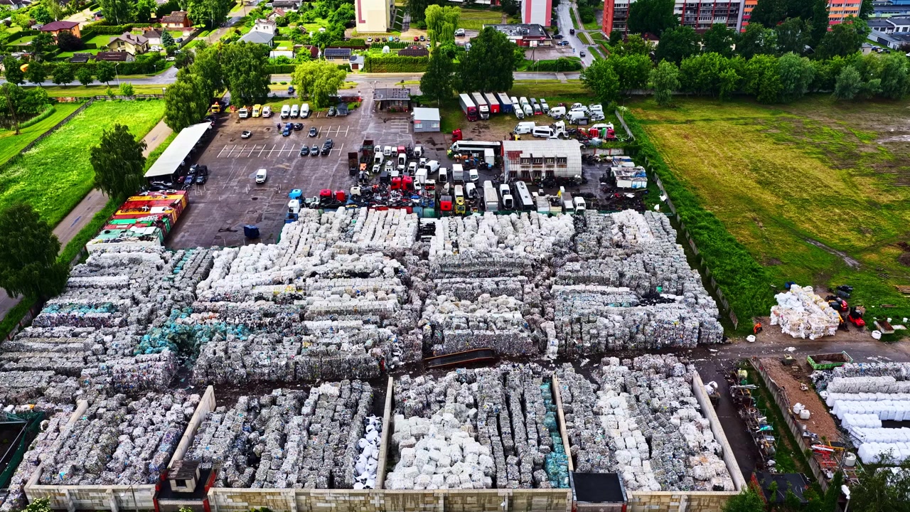 分別されたプラスチック廃棄物のベールで満たされたリサイクルヤードの空撮。ドローンによる全景撮影