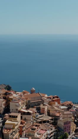 vertical aerial view of castelmola town in sicily. flying high up in the mountains with a fabulous view to mediterranean sea. sunny summer day in sicily.