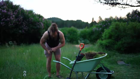 caucasian man working on the lawn yard with shovel and wheelbarrow