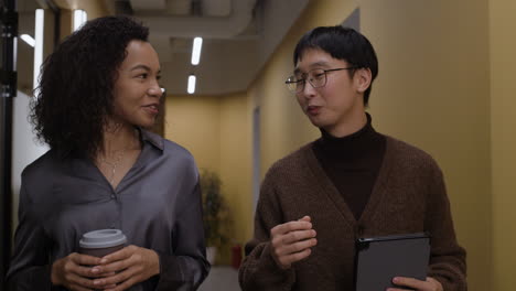 business colleagues discussing in office corridor