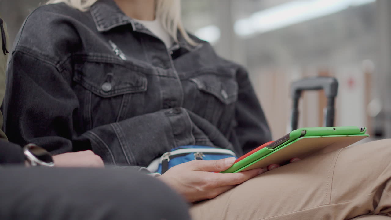 mujer esperando en el aeropuerto con una tableta