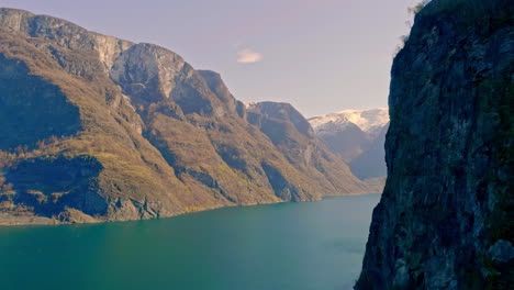 aerial drone shot over valley from high rocky mountain range in norway at daytime