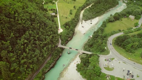 aerial view of a group of people doing rafting going under a bridge.