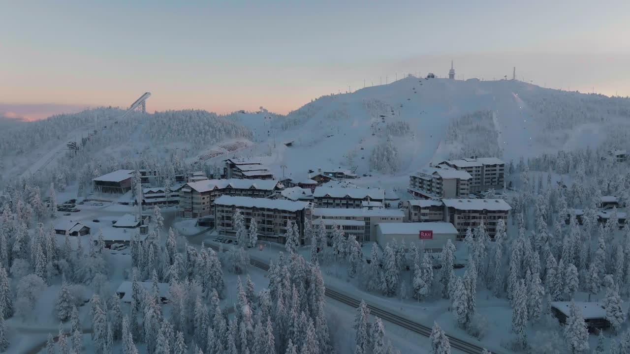 Aerial view orbiting the Rukavillage, freezing winter sunset in Kuusamo, Finland