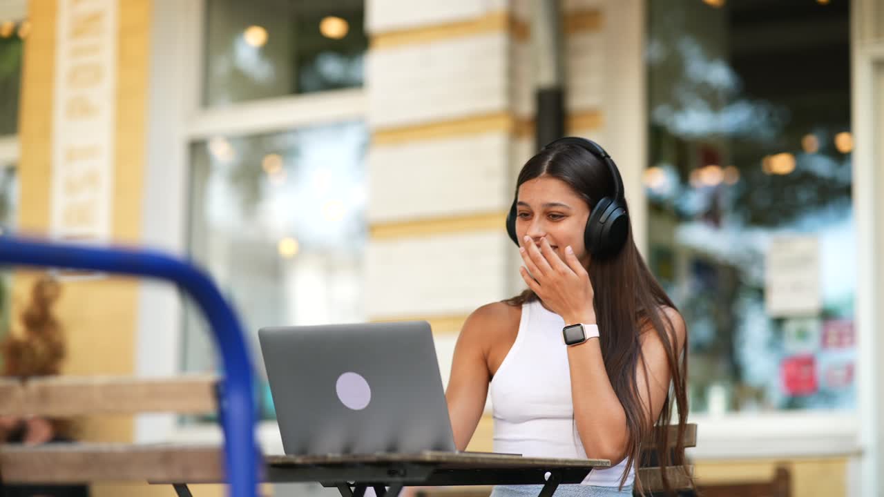 Young Woman Working on Laptop in a Cafe