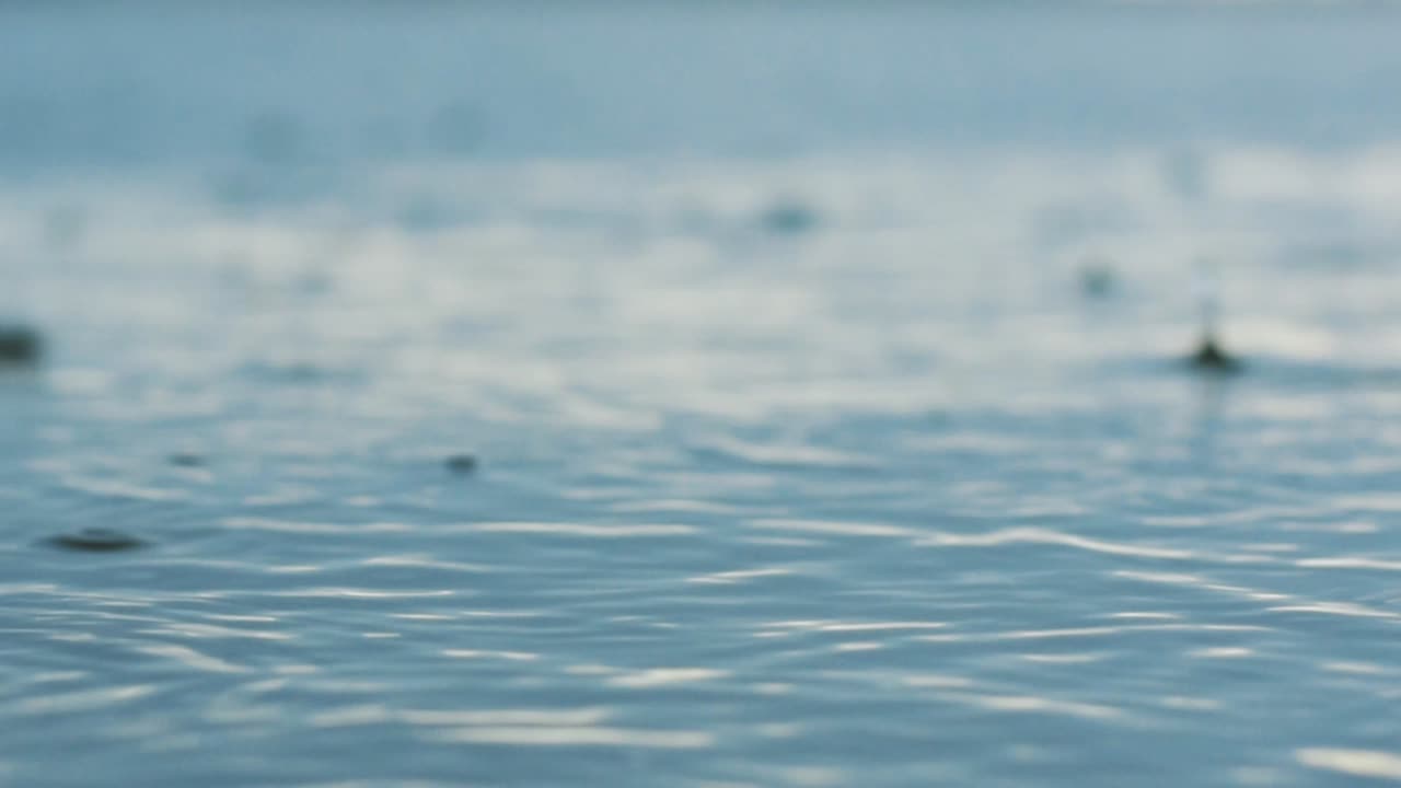 Rain on the lake, closeup of raindrops in the lake in the afternoon