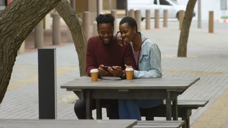 couple using mobile phone in outdoor cafe 4k