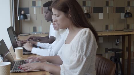 pretty female professional sitting at counter next to her teammates