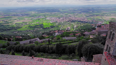 aerial pull-out of stone tower in town of cortona on hill in tuscany