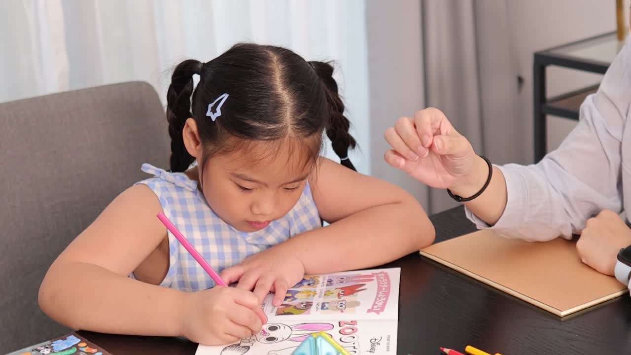 Una bambina si concentra sul colorare mentre i suoi genitori le offrono supporto e guida in casa.
