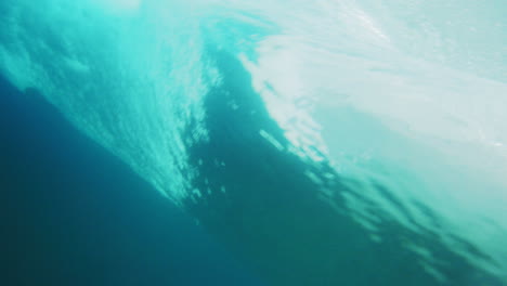 Detailed-closeup-of-rearview-of-clear-ocean-wave-barreling-and-rising