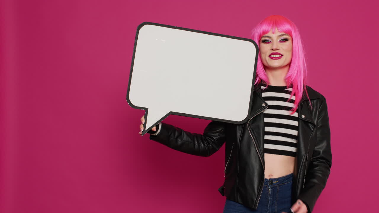 Beautiful trendy person holding isolated speech bubble in studio