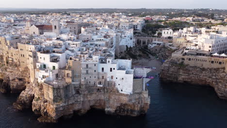 Aerial-circling-shot-of-coast-of-Polignano-a-Mare-at-sunset