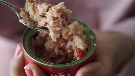 person eating tuna from a can