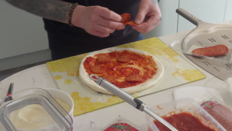 learn how to create a flavourful homemade pizza by adding sauce and toppings in a cosy kitchen setting, perfect for family and friends.