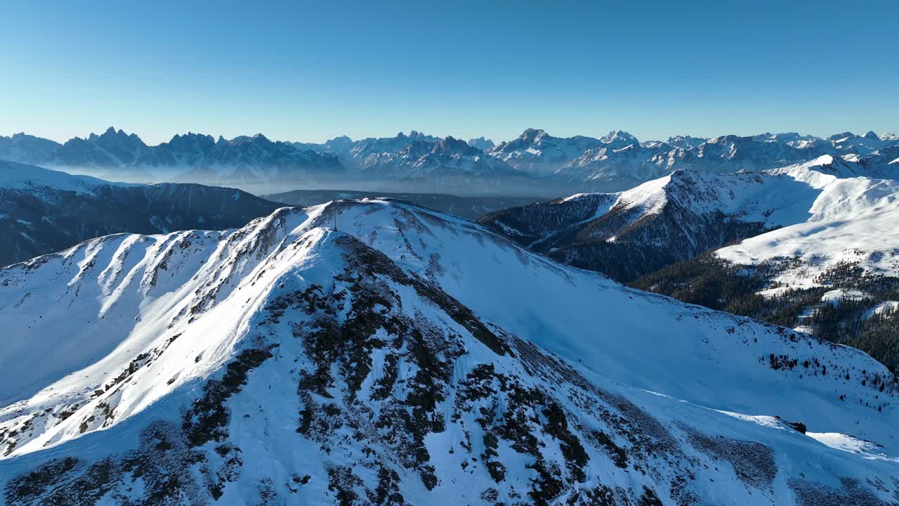 cumbre de la montaña con cruz y los dolomitas en el fondo