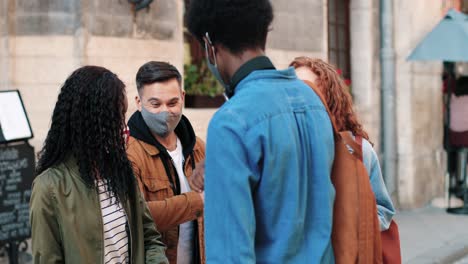 group of multiethnic friends wearing mask and greeting at each other with the elbows