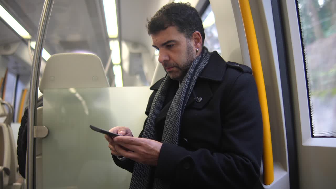 Man using a smartphone while commuting on public transport