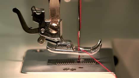 costurera por la aguja a través de la placa de aguja y hace un bucle para coser en una máquina de coser