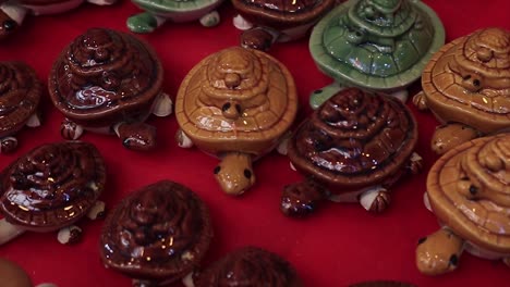 small colorful ceramic turtles displayed for sale in a fair