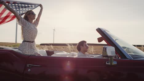 Video-De-Una-Pareja-Conduciendo-Un-Auto-Con-Una-Bandera-Americana.