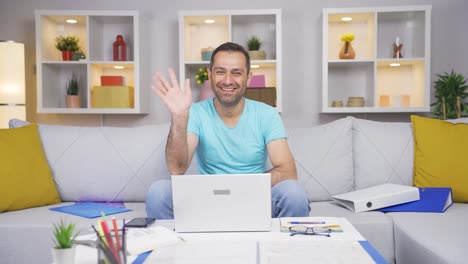 home office worker man waving at camera.