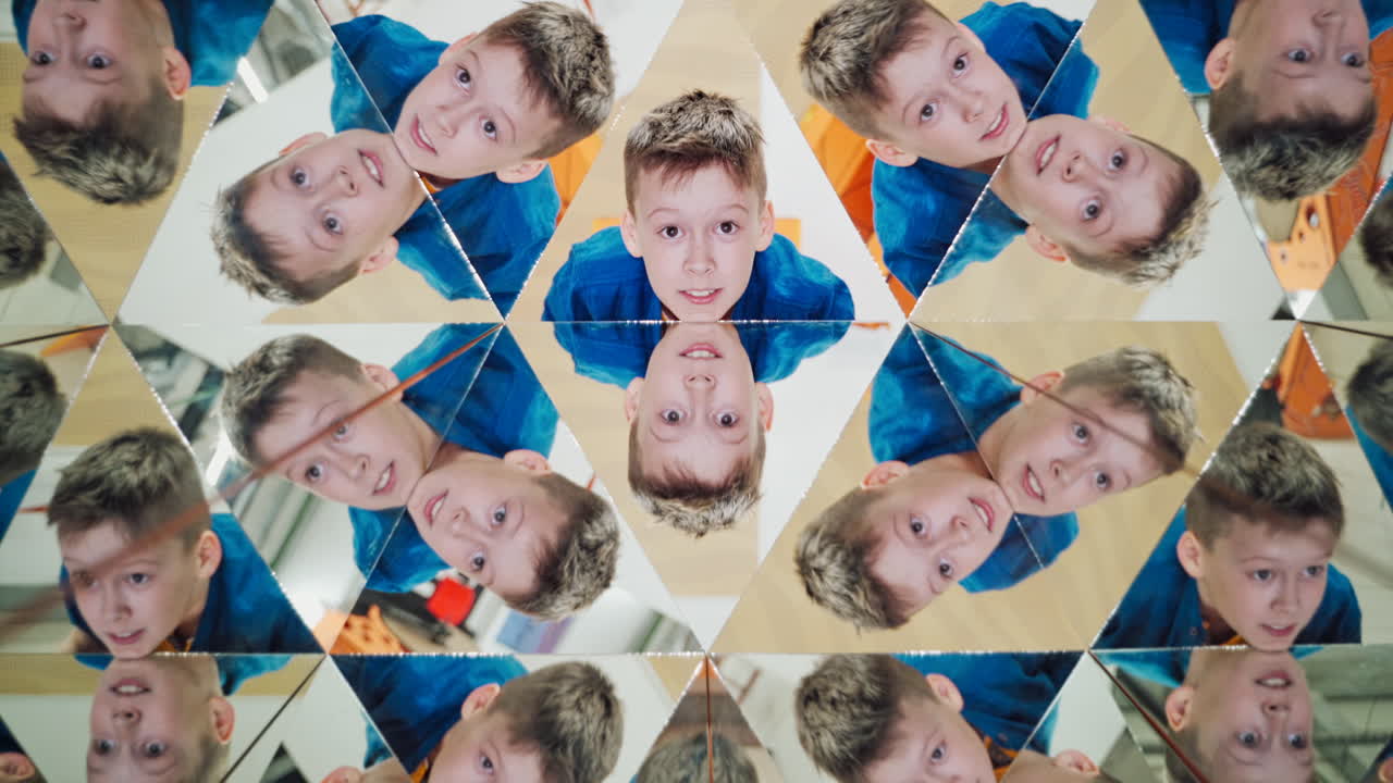Curious boy in blue and yellow shirt reflecting in the mirrors of kaleidoscope. Abstract montage of a child in many triangle parts of the kaleidoscope.