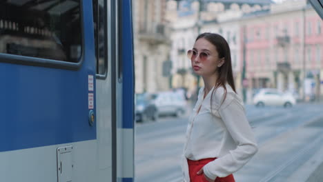 young woman waiting for tram in the city