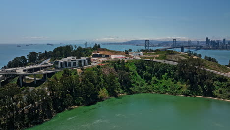 San-Francisco-California-Antena-V102-Drone-Flyover-Yerba-Buena-Island-Capturando-El-Puente-De-La-Bahía-Y-El-Paisaje-Urbano-Del-Centro-A-Lo-Largo-Del-Horizonte-A-Través-Del-Agua-Durante-El-Día---Filmado-Con-Mavic-3-Cine---Mayo-De-2022