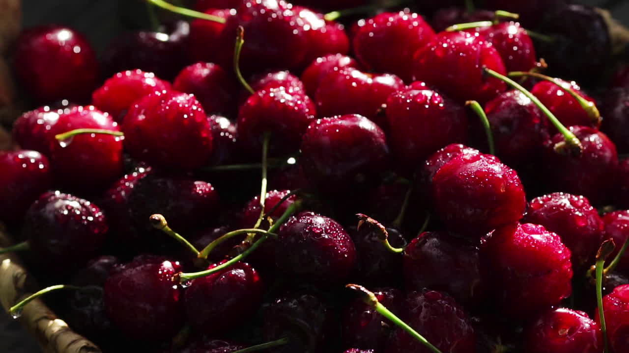 cerezas dulces rojas maduras de cerca con gotas de agua en la canasta en la hierba