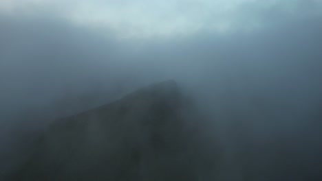 Flying-through-clouds-and-revealing-mountain-in-gloomy-weather