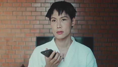woman using smartphone in bathrobe