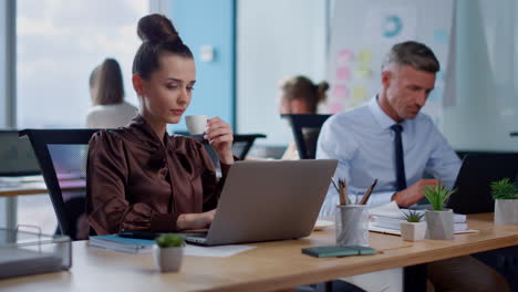 thoughtful business woman looking at laptop screen