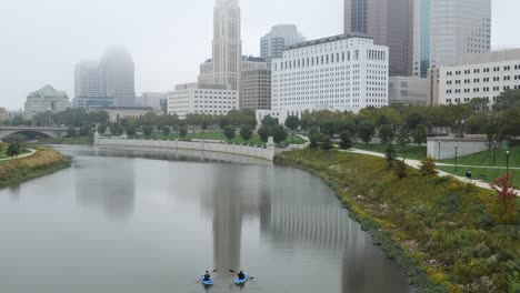 Kayaking-in-downtown-Columbus,-Ohio-on-the-Scioto-River-on-a-foggy-day