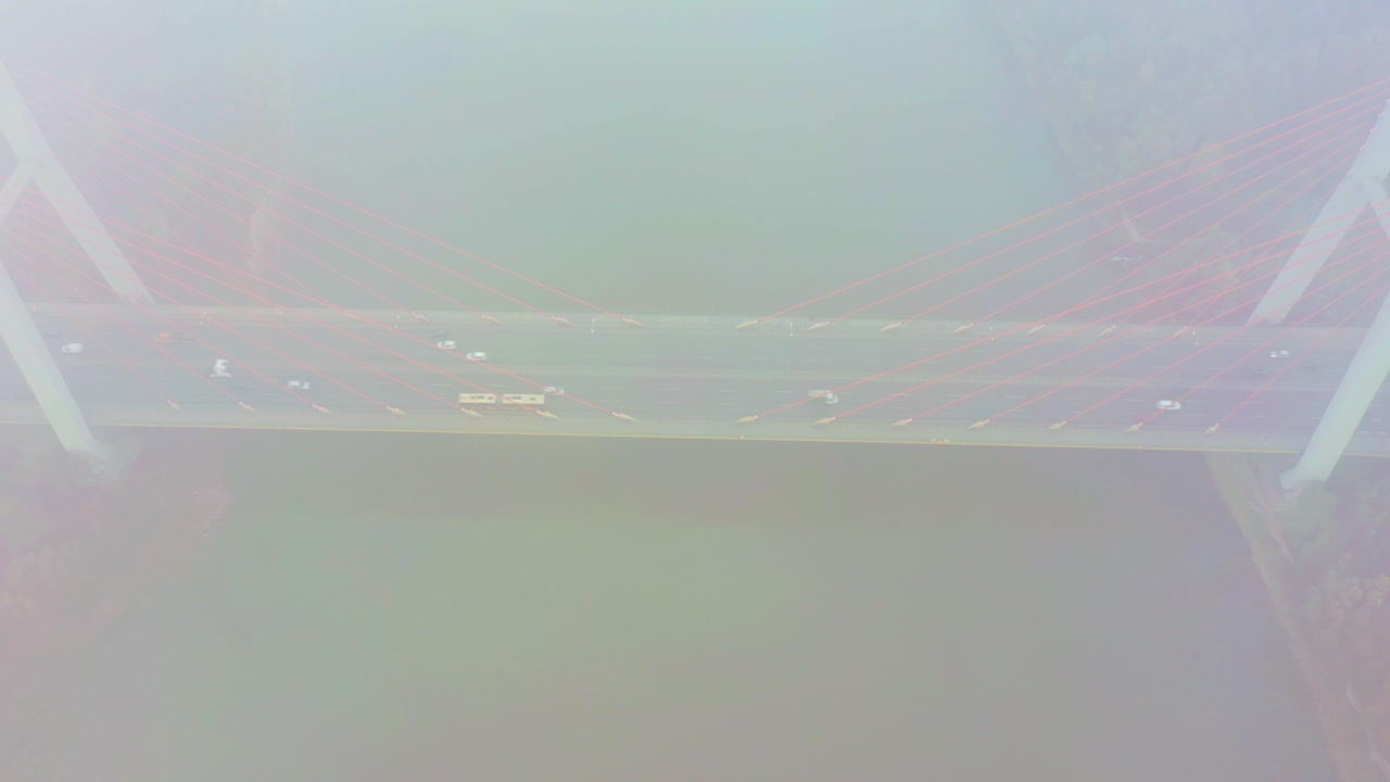 Aerial drone view. bridge in the rays of a sunny morning. Autumn haze in the air, cars are driving across the bridge. Cloudy day