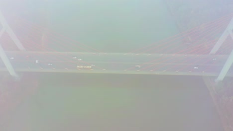 aerial drone view. bridge in the rays of a sunny morning. autumn haze in the air, cars are driving across the bridge. cloudy day