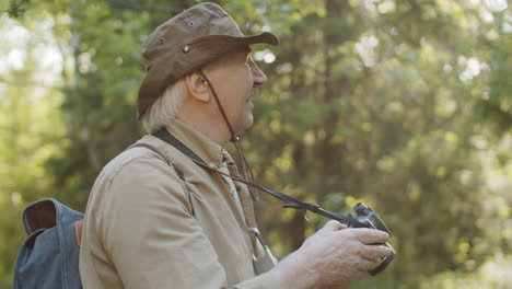 senior man taking pictures in the forest