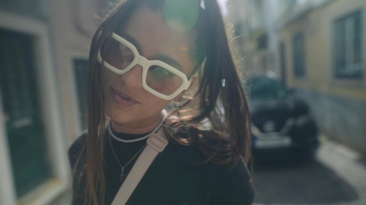 Jovem mulher elegante caminhando por uma rua europeia ensolarada
