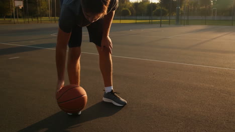 man dribbling a basketball on an outdoor court